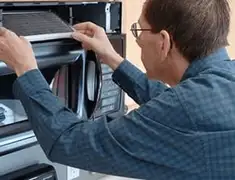 Appliance repair technician replacing a microwave vent filter in Detroit, MI