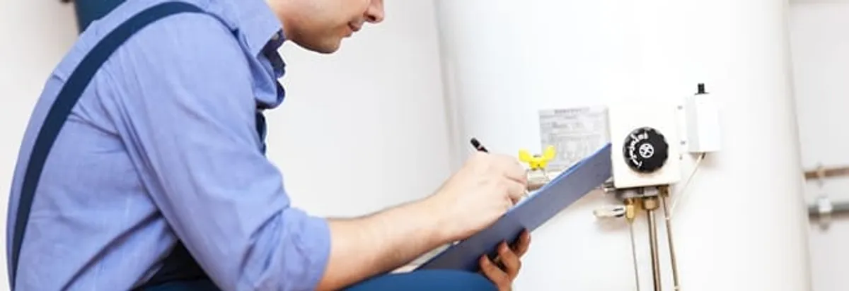 Water heater repair technician inspecting the unit and recording service notes in Detroit, MI